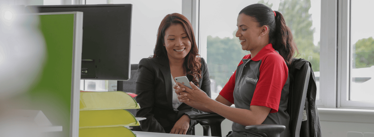 Sales page from Rentokil Initial displaying two employees in conversation, representing teamwork and professional service delivery.